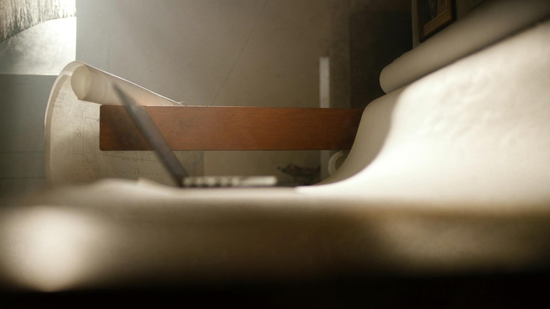 Arbeitstisch mit Bauplänen in warmem Fensterlicht