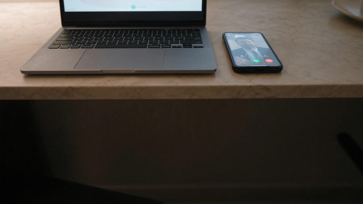 Warmer Arbeitsplatz mit Laptop, an dem eine Anfrage beantwortet wird